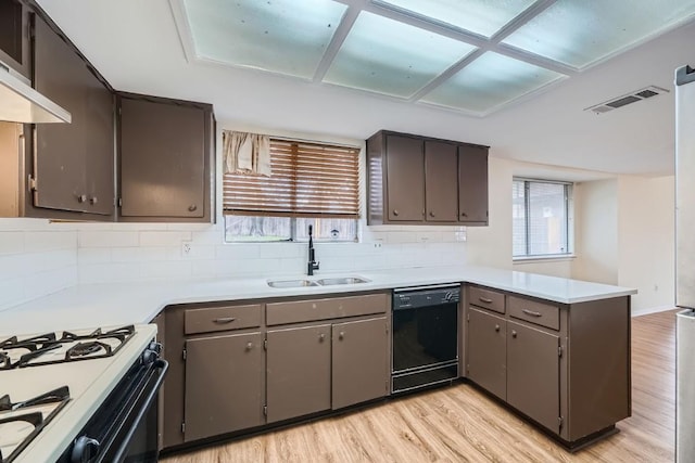 kitchen featuring sink, dishwasher, tasteful backsplash, kitchen peninsula, and light wood-type flooring