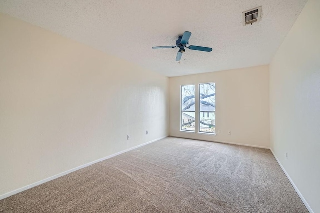 carpeted spare room with ceiling fan and a textured ceiling