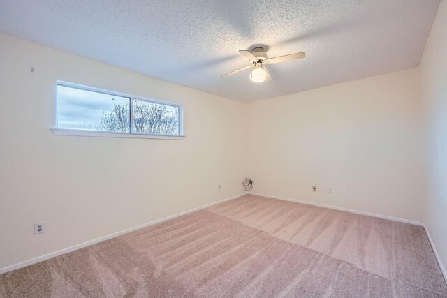 carpeted empty room with ceiling fan and a textured ceiling