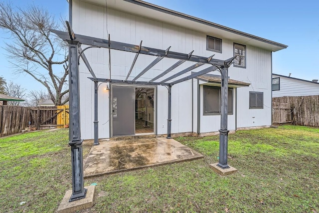 rear view of house featuring a pergola, a patio area, and a lawn