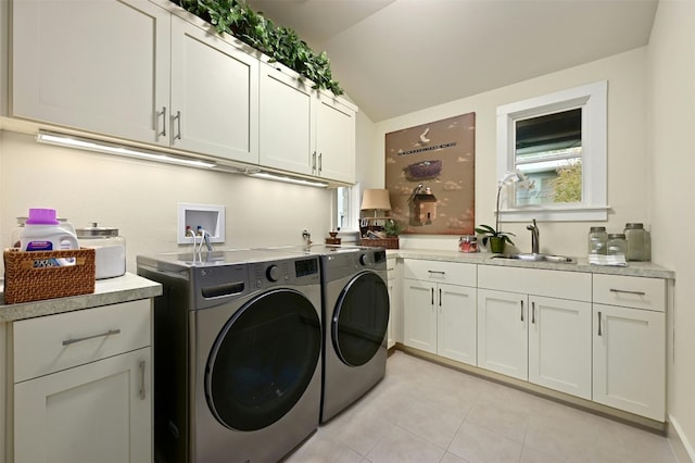 clothes washing area featuring cabinets, sink, light tile patterned floors, and independent washer and dryer