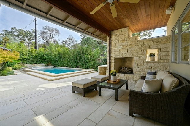 view of patio / terrace featuring ceiling fan and an outdoor living space with a fireplace