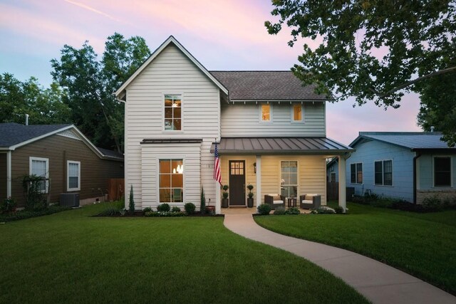 view of front of property featuring central AC unit and a yard