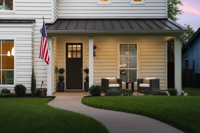 1911 W 36th St, Austin, TX 78731 - exterior entry at dusk featuring a standing seam roof, metal roof, and a lawn