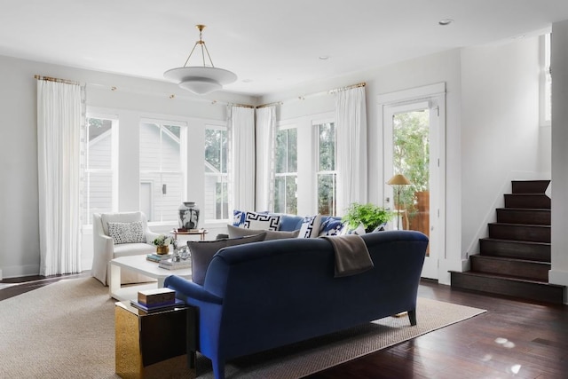 living room featuring stairs, plenty of natural light, and wood finished floors