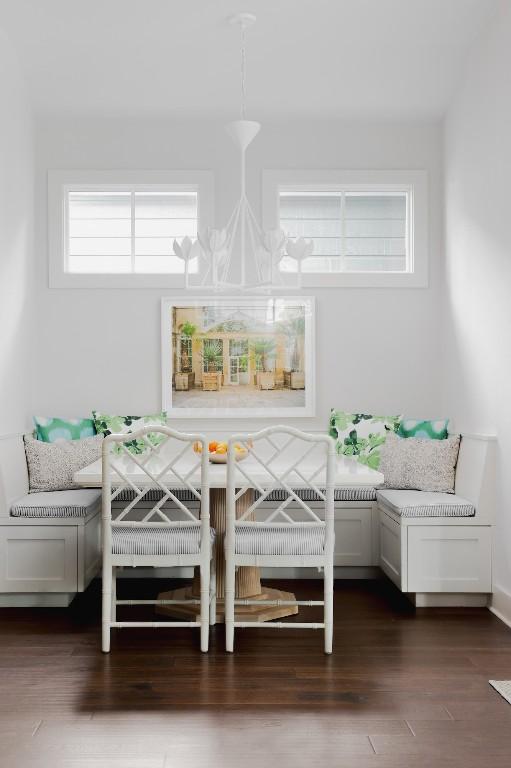 unfurnished dining area featuring breakfast area, an inviting chandelier, and dark wood-type flooring