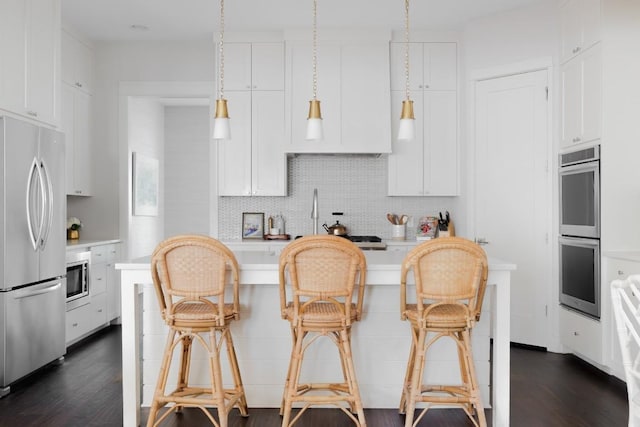 kitchen featuring appliances with stainless steel finishes, dark wood-style flooring, white cabinets, and decorative backsplash