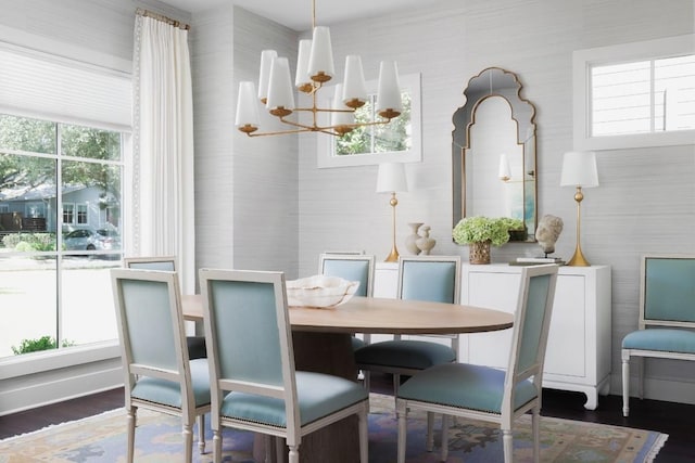 dining space featuring wood finished floors and an inviting chandelier