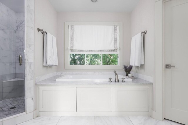 bathroom featuring independent shower and bath