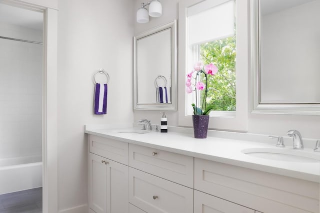 bathroom featuring tiled shower / bath combo and vanity