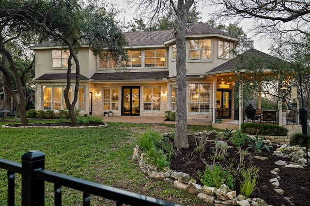 back of property with a lawn and a patio