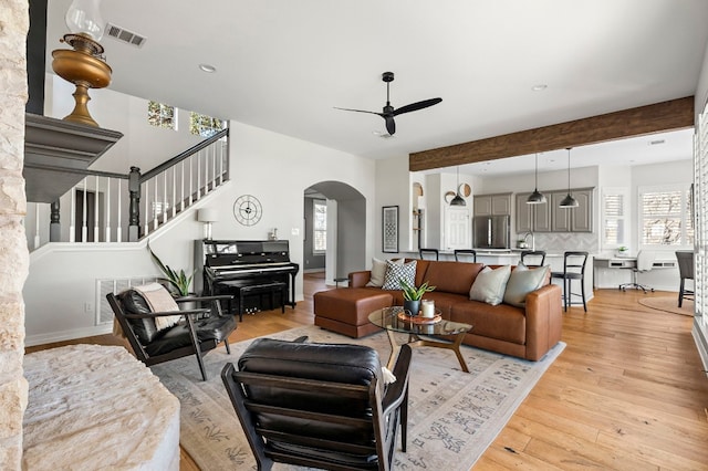 living room featuring beamed ceiling, ceiling fan, and light hardwood / wood-style floors