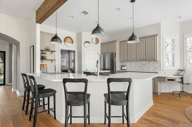 kitchen featuring sink, decorative light fixtures, gray cabinets, and stainless steel fridge