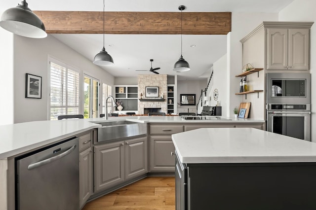 kitchen featuring gray cabinetry, sink, pendant lighting, and appliances with stainless steel finishes