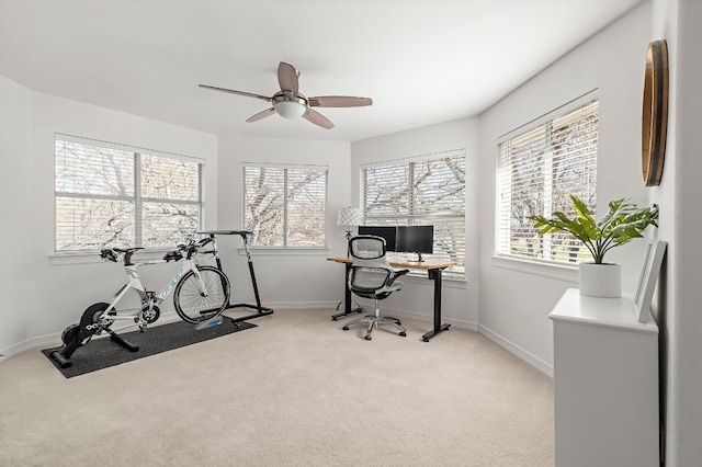 carpeted office space featuring ceiling fan and a healthy amount of sunlight