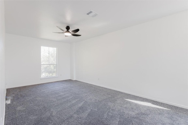 spare room featuring dark carpet and ceiling fan