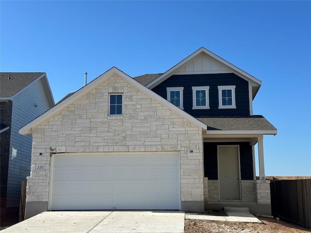 view of front of house with an attached garage, fence, driveway, roof with shingles, and board and batten siding