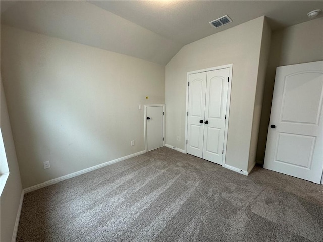 unfurnished bedroom with visible vents, baseboards, a closet, carpet, and lofted ceiling