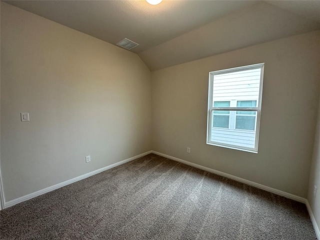 unfurnished room with visible vents, baseboards, carpet, and vaulted ceiling