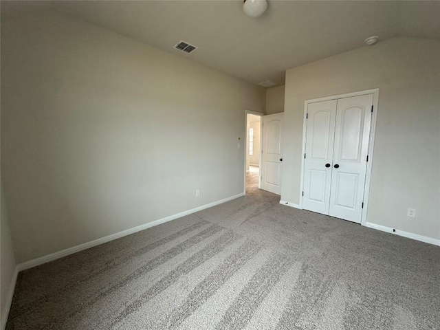 unfurnished bedroom with visible vents, baseboards, carpet, and a closet