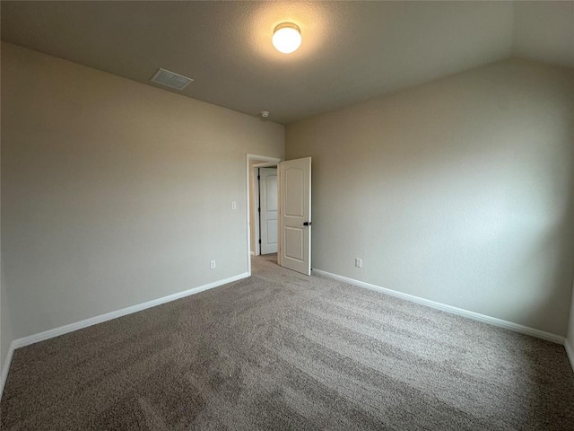 carpeted spare room with visible vents and baseboards