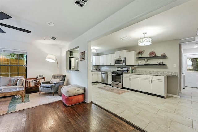 kitchen with white cabinetry, light hardwood / wood-style flooring, appliances with stainless steel finishes, pendant lighting, and ceiling fan