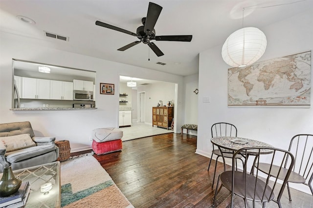 living room with ceiling fan and dark hardwood / wood-style floors