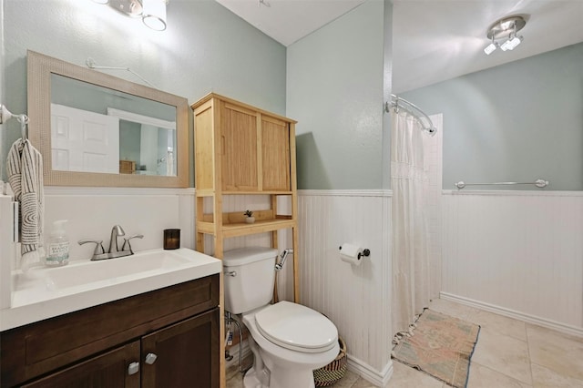 bathroom with tile patterned floors, toilet, curtained shower, and vanity