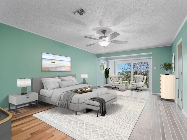 bedroom with hardwood / wood-style floors, a textured ceiling, ceiling fan, and access to exterior