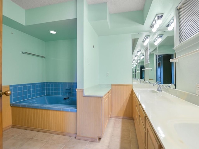 bathroom with tile patterned flooring, vanity, a bath, a textured ceiling, and wood walls