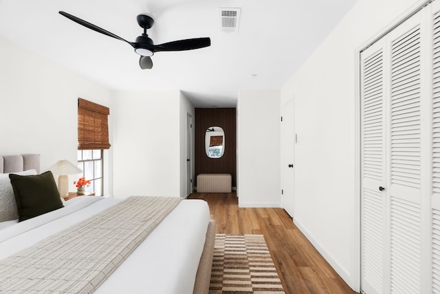 bedroom with radiator, light hardwood / wood-style flooring, a closet, and ceiling fan