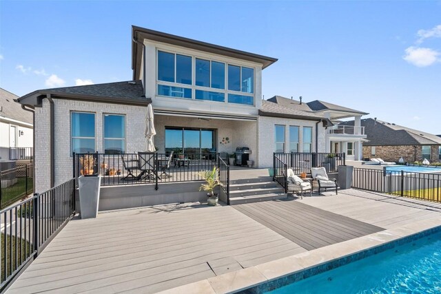 rear view of house with a pool side deck and a patio