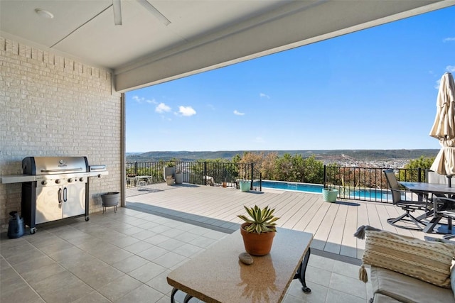 view of patio / terrace featuring a fenced in pool, grilling area, and ceiling fan