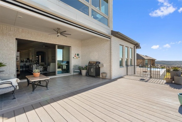 wooden deck with area for grilling and ceiling fan