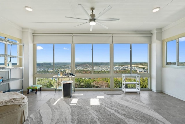 unfurnished sunroom featuring ceiling fan and a healthy amount of sunlight