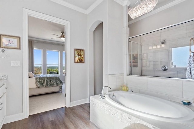 bathroom with hardwood / wood-style flooring, ceiling fan, vanity, ornamental molding, and plus walk in shower