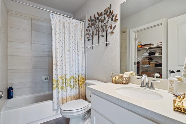 bathroom featuring toilet, a textured wall, shower / bath combo, and vanity