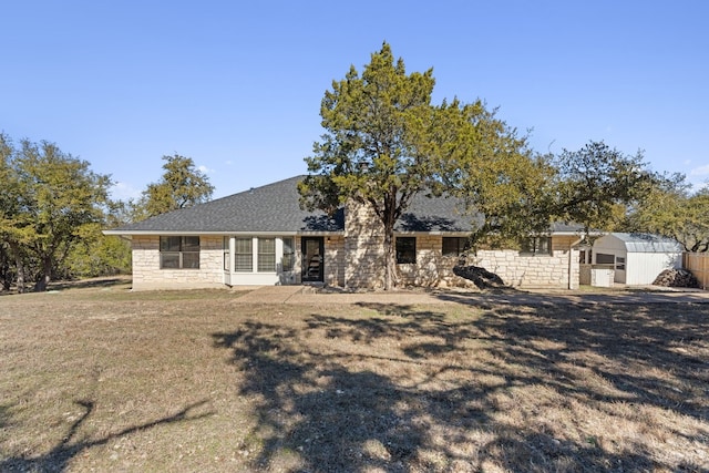 1043 Windmill Rd, Dripping Springs, TX 78620 - view of front of property with stone siding, a front yard, and roof with shingles