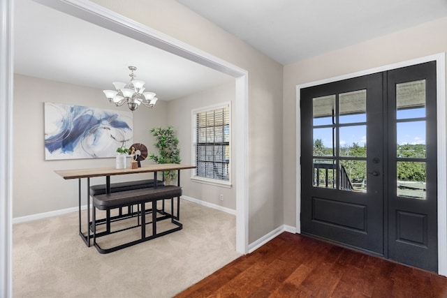 foyer with dark hardwood / wood-style flooring and a chandelier