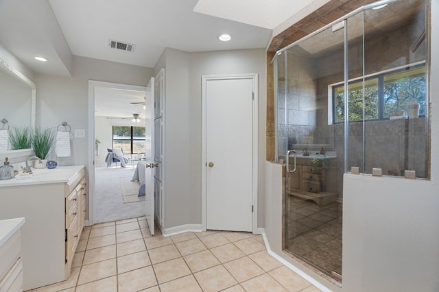 bathroom with tile patterned flooring, vanity, and walk in shower