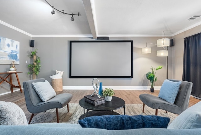 home theater room with hardwood / wood-style flooring and ornamental molding