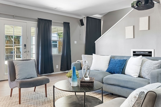 living room with ornamental molding and light wood-type flooring