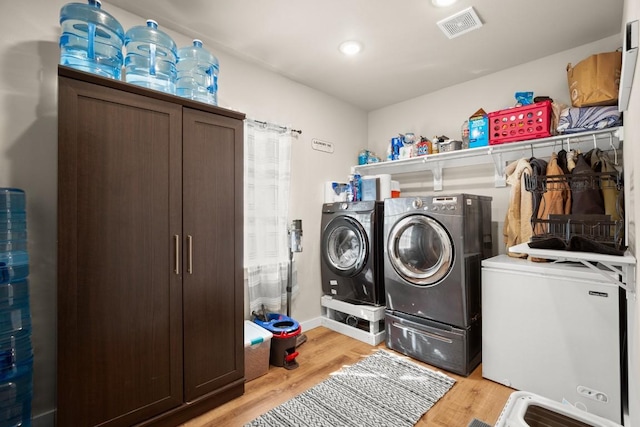 clothes washing area featuring light hardwood / wood-style floors and independent washer and dryer