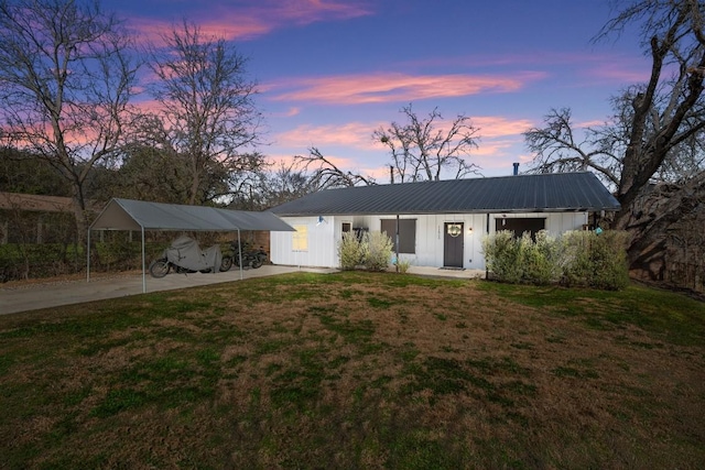 view of front of home featuring a lawn and a carport