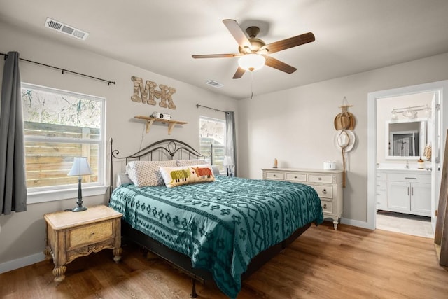 bedroom with ceiling fan, ensuite bathroom, and light hardwood / wood-style flooring