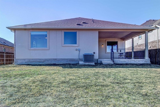 rear view of property featuring cooling unit and a yard