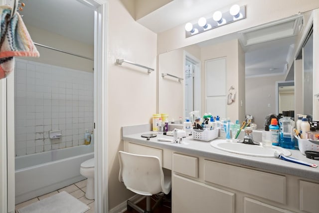 full bathroom featuring tiled shower / bath, vanity, toilet, crown molding, and tile patterned floors