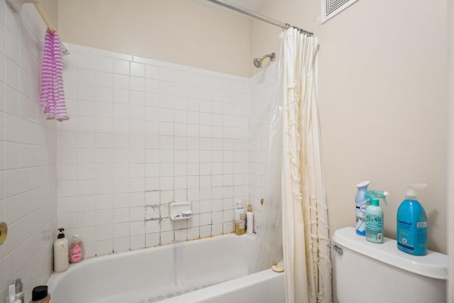 bathroom featuring shower / bath combination with curtain and toilet