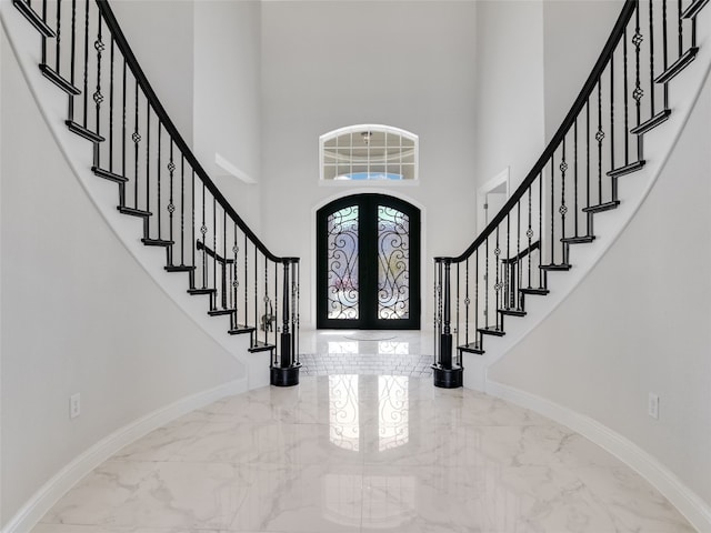 foyer featuring french doors and a towering ceiling