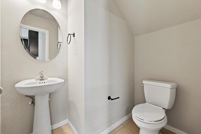 bathroom featuring sink, lofted ceiling, toilet, and tile patterned flooring